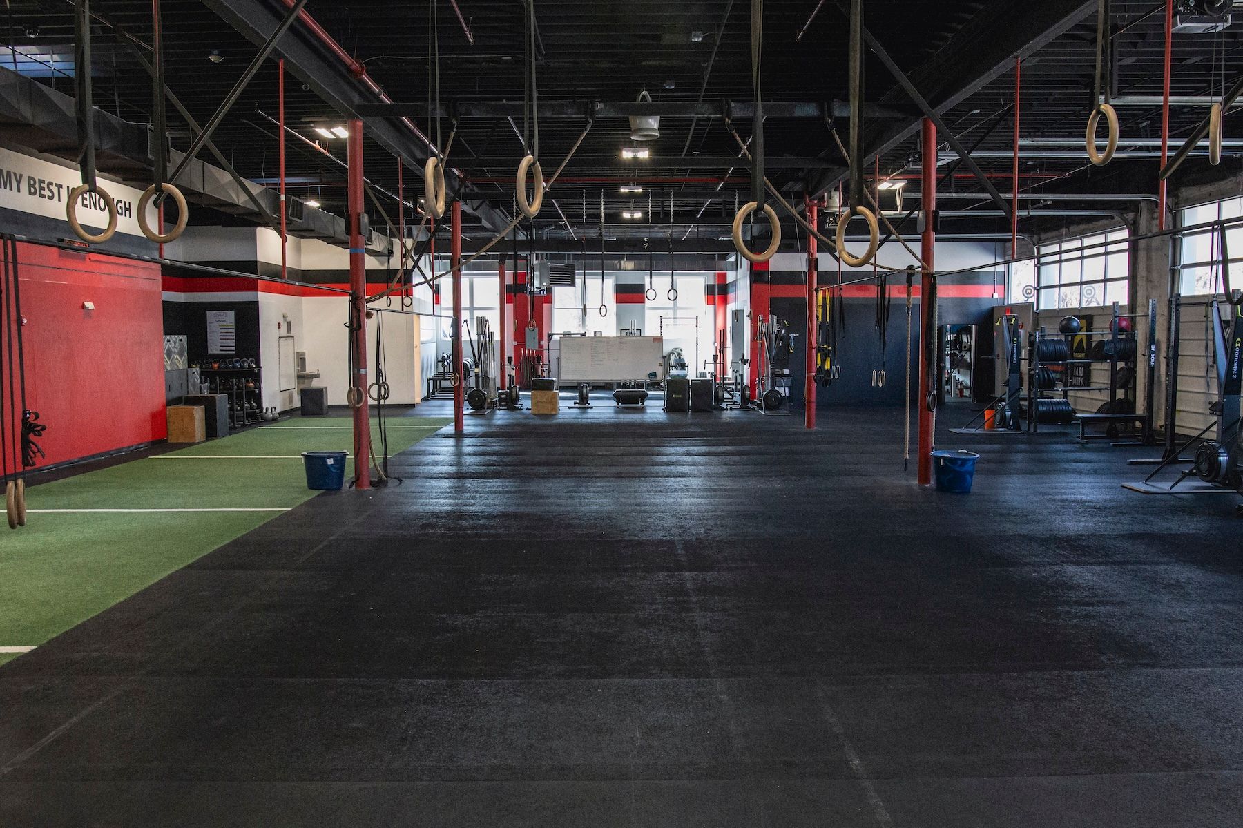 A large empty gym with a lot of rings hanging from the ceiling.