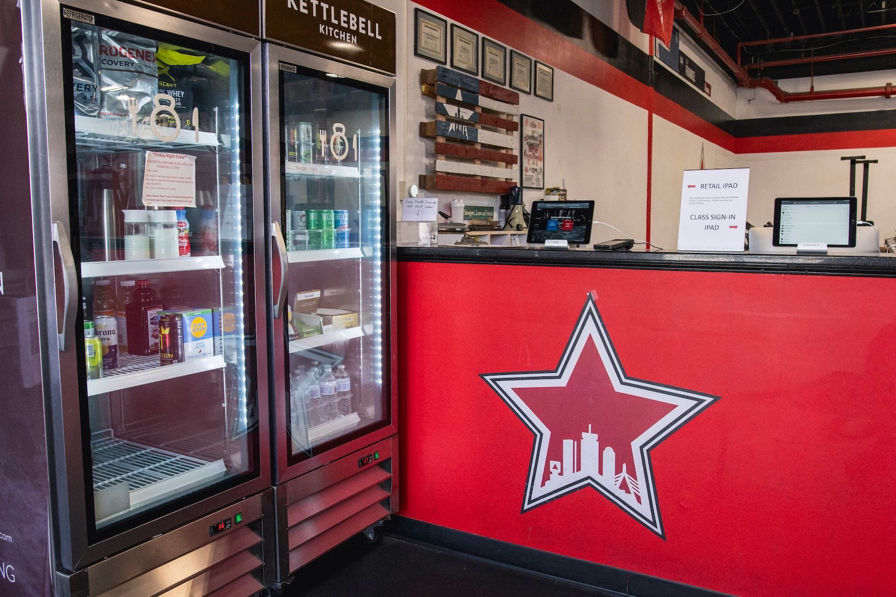 A restaurant with two refrigerators and a red counter with a star on it.