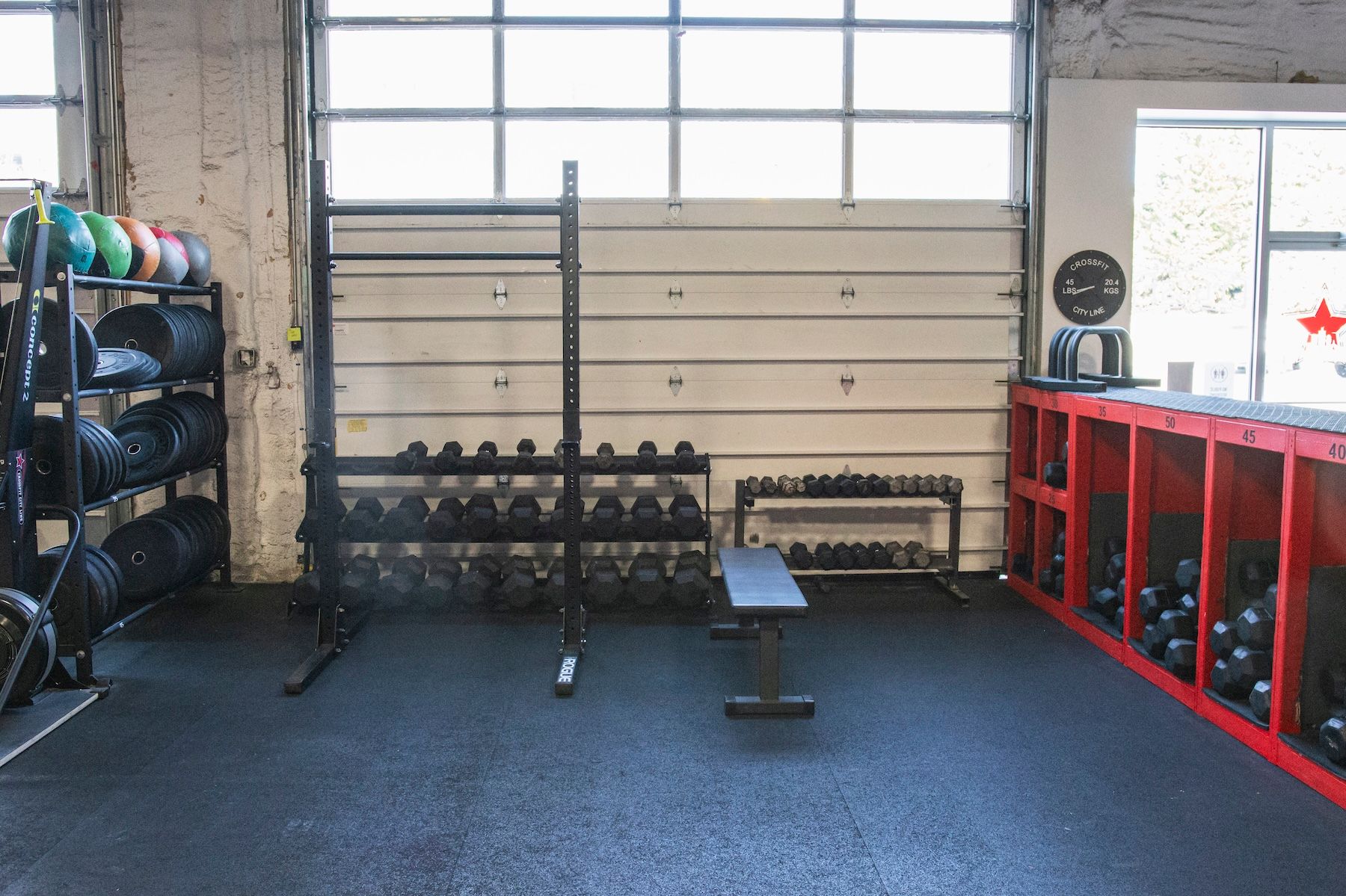 A gym with a lot of dumbbells and a bench.
