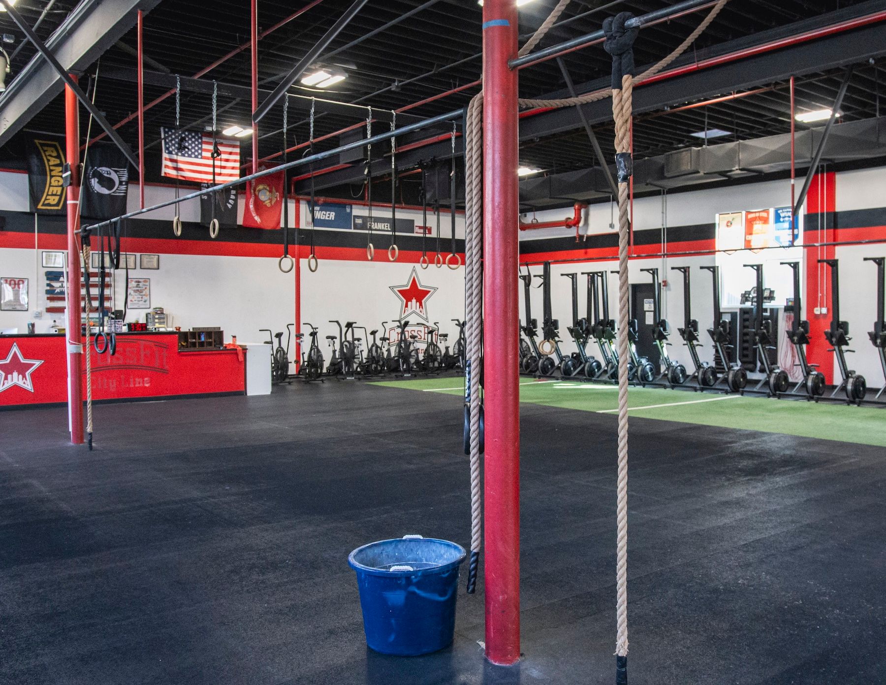 An empty gym with a blue bucket on the floor