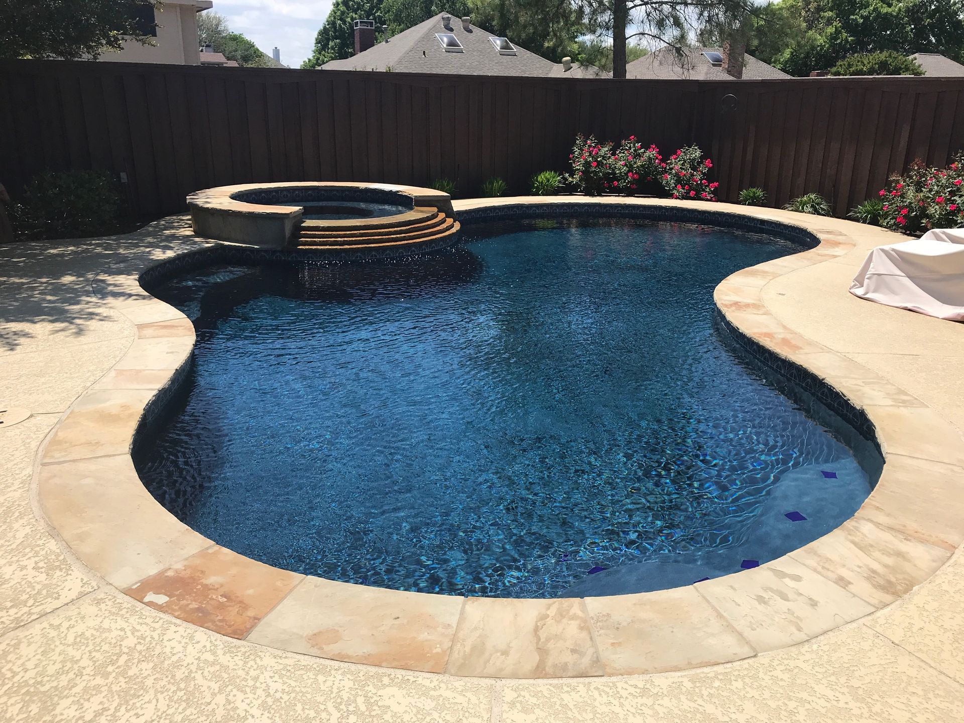 A large swimming pool with a hot tub in the middle of it.