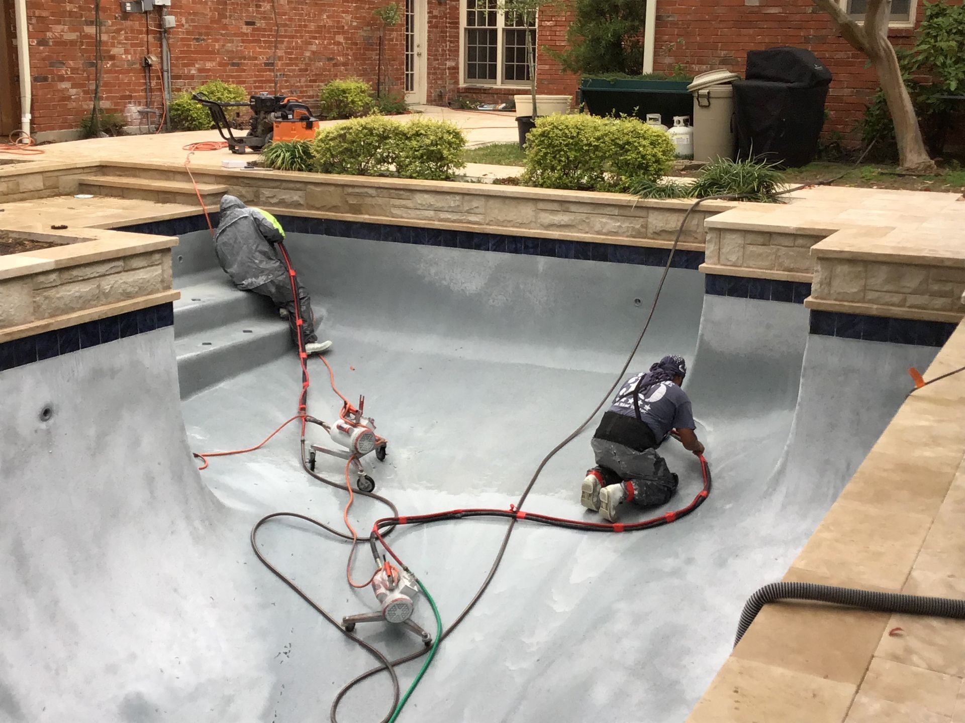 A man is kneeling in the middle of a swimming pool.