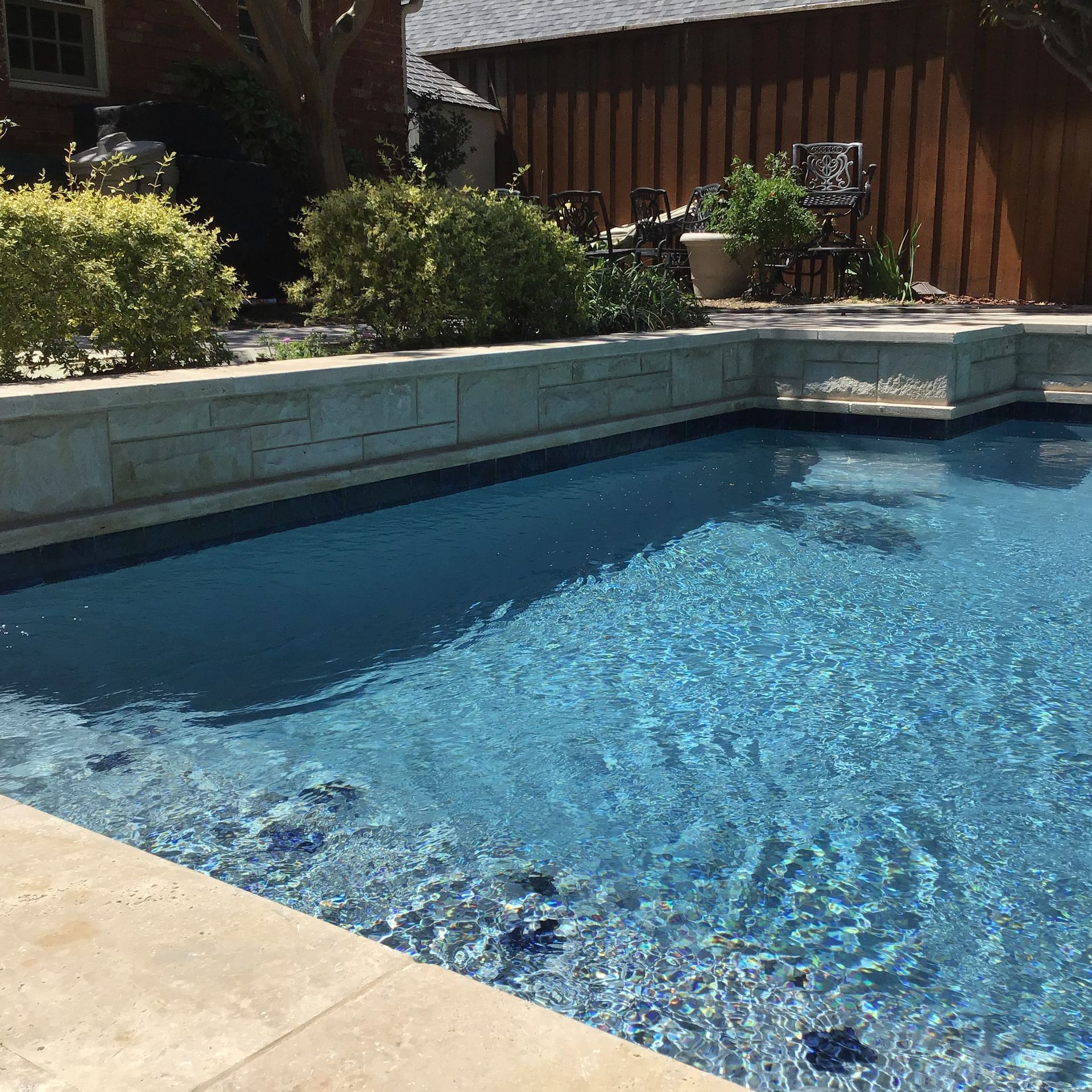 A large swimming pool with a brick wall surrounding it