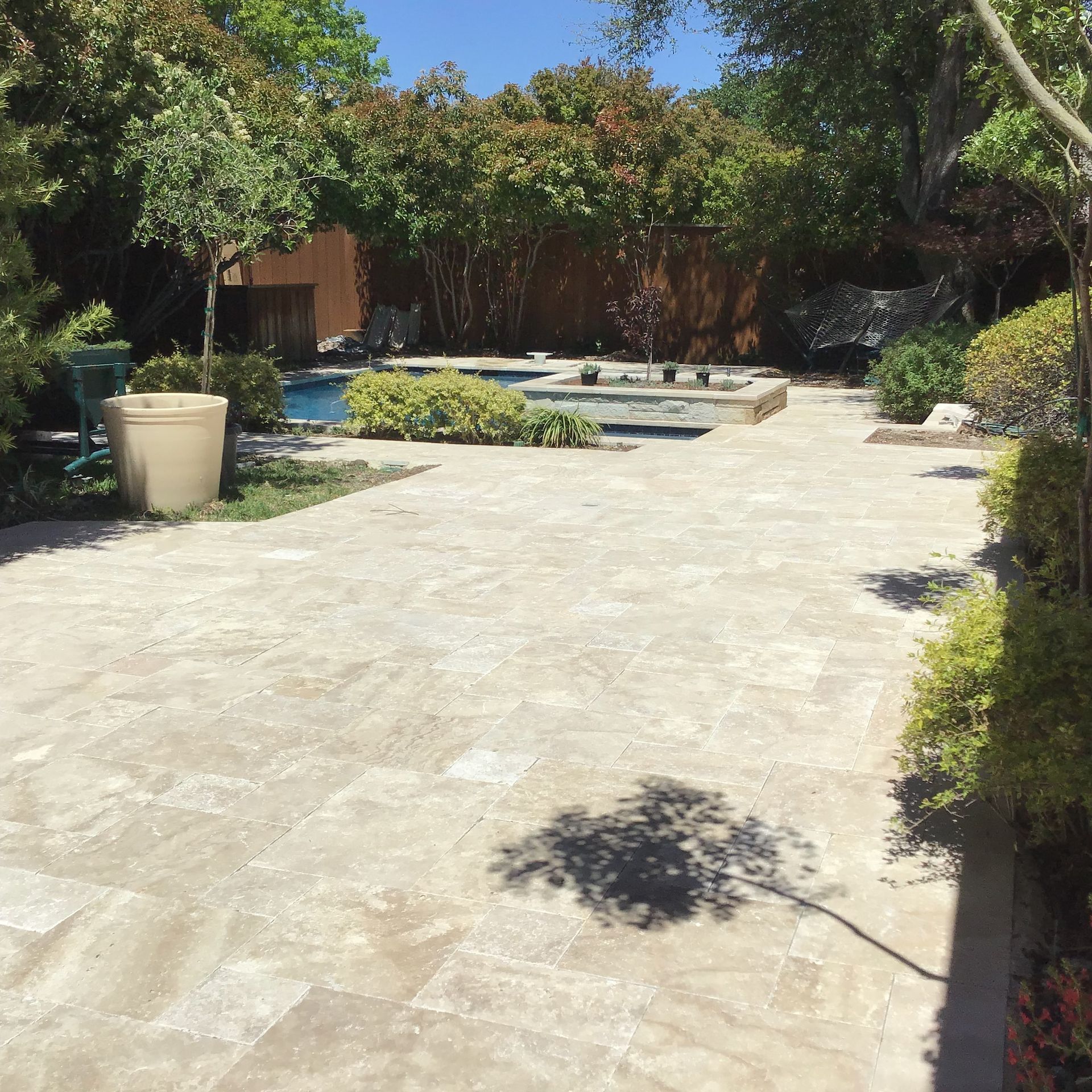 A patio with a swimming pool in the background