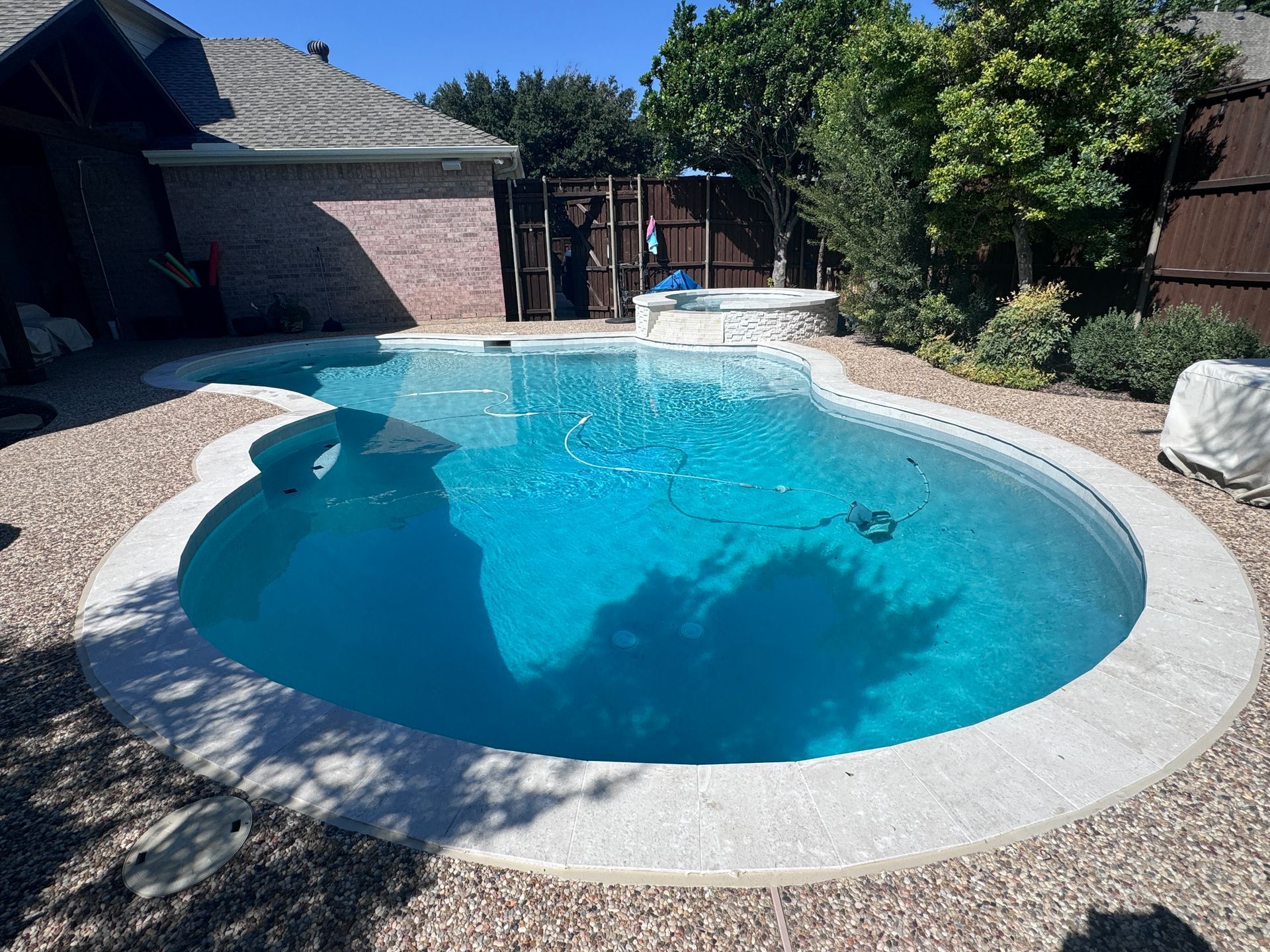 A large swimming pool in the backyard of a house.