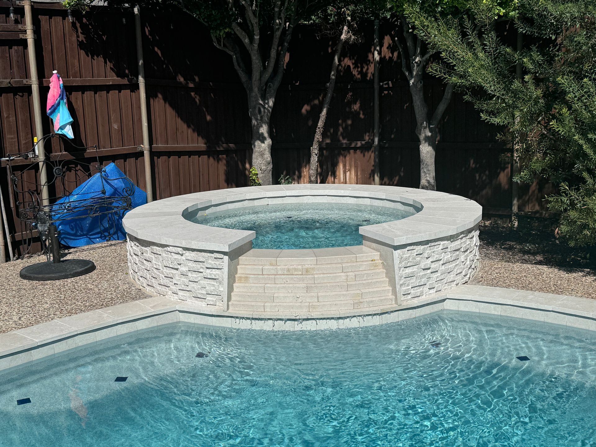 A swimming pool with a hot tub in the middle of it.