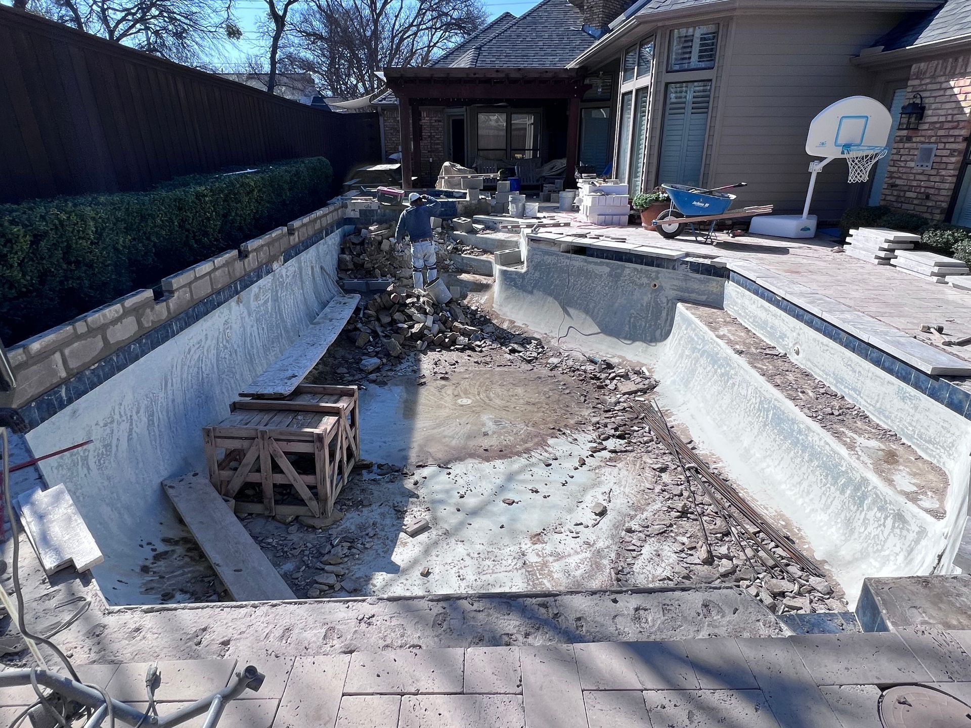 A swimming pool is being remodeled in the backyard of a house.