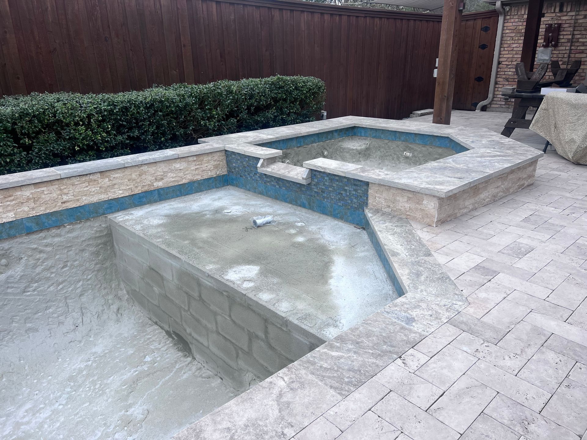A hot tub is being built in the backyard of a house.