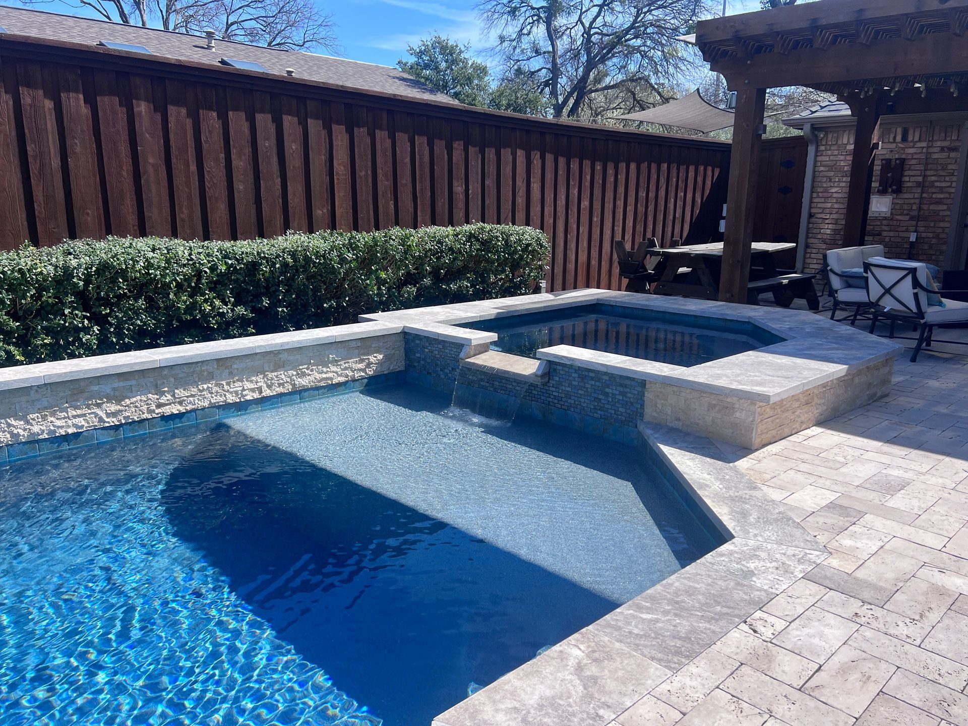 There is a swimming pool and a hot tub in the backyard.