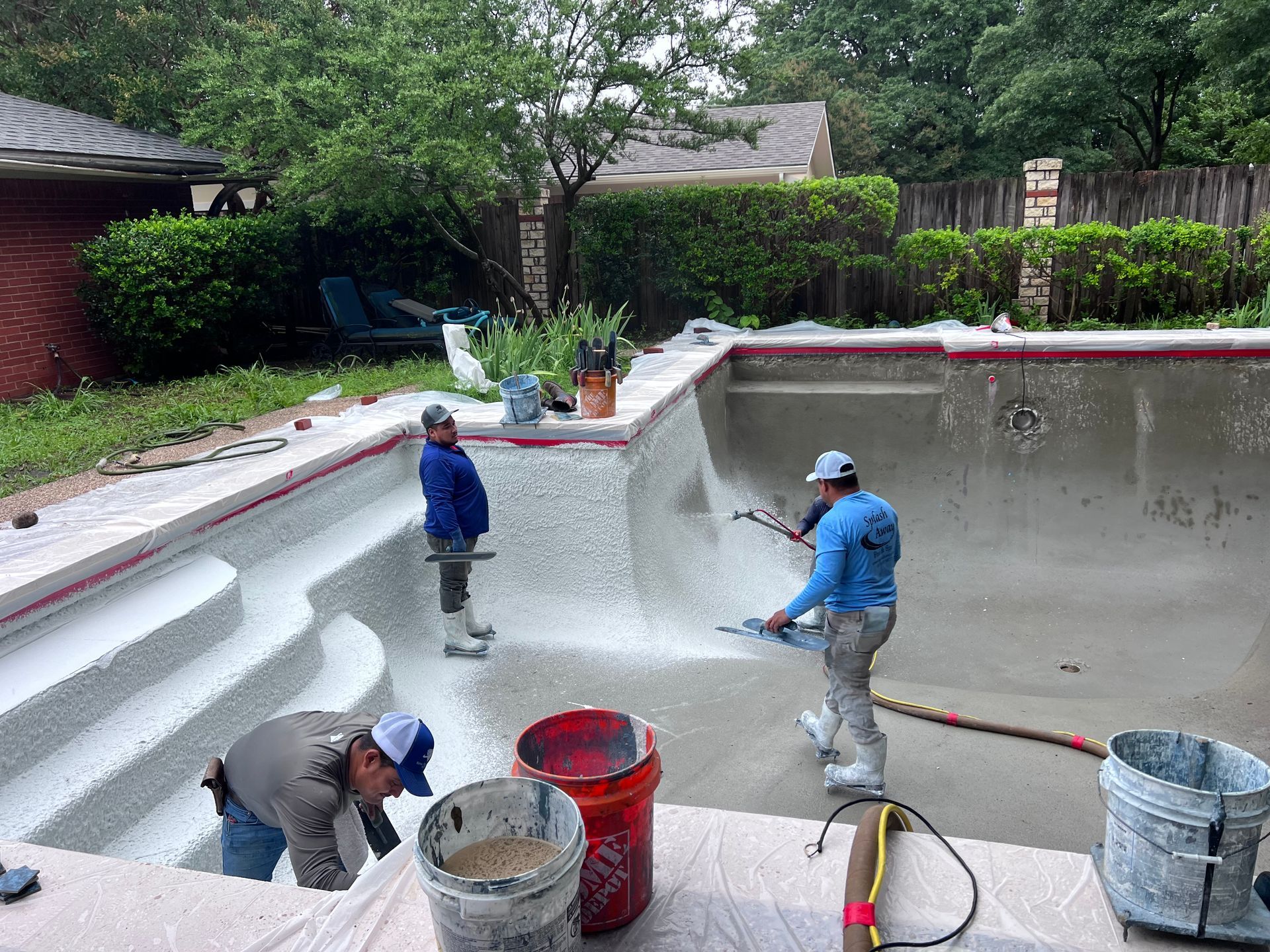 A group of men are working on a swimming pool.