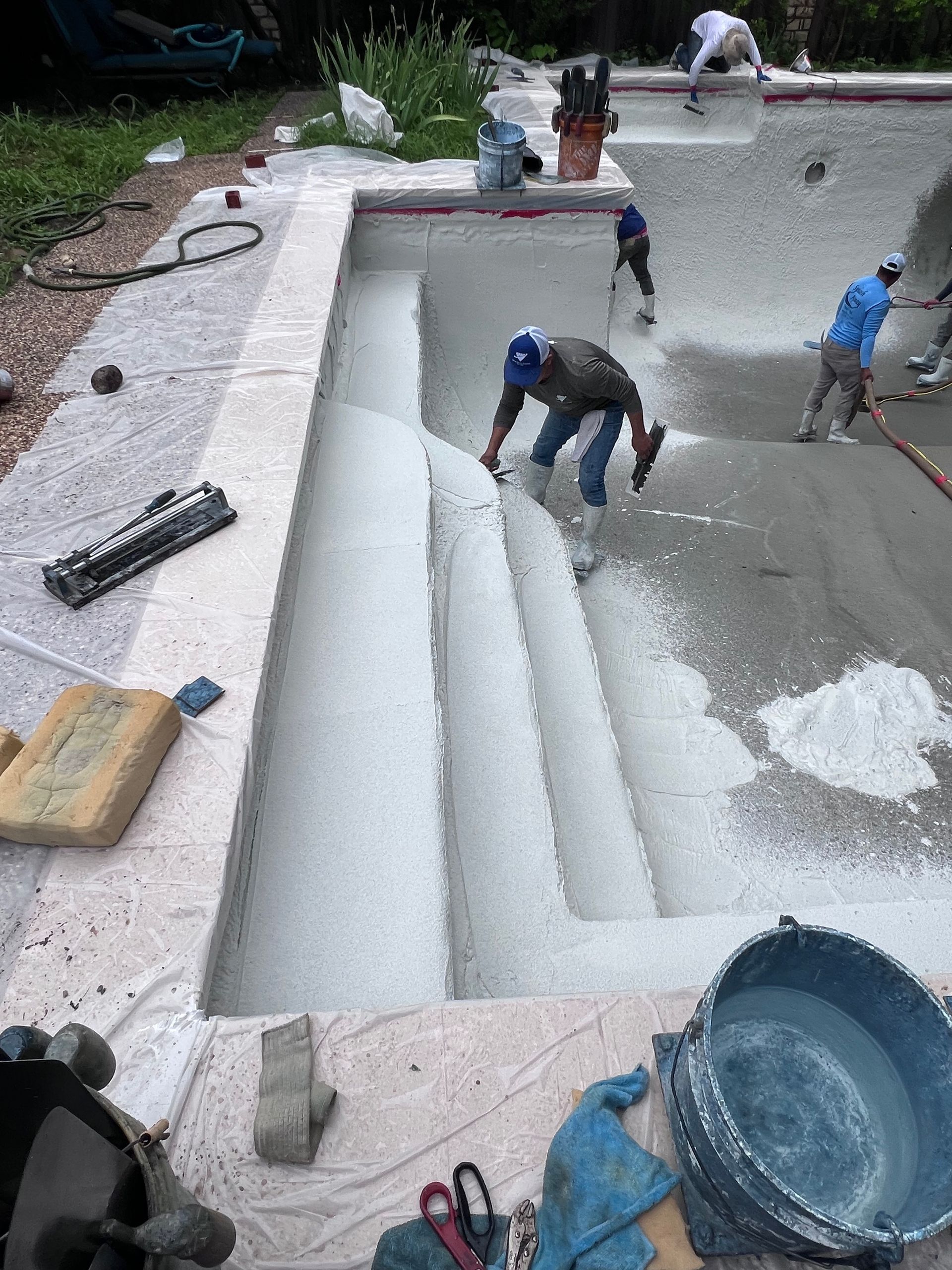A group of men are working on a swimming pool.