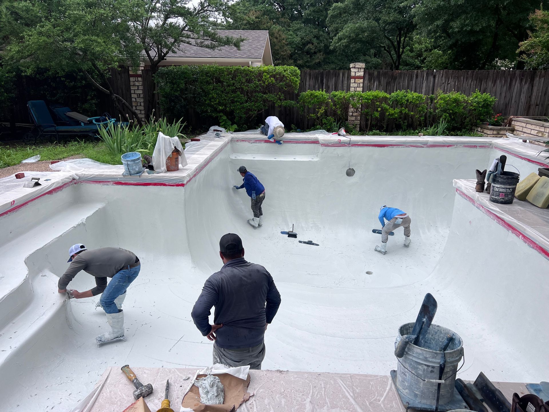 A group of men are working on a swimming pool.