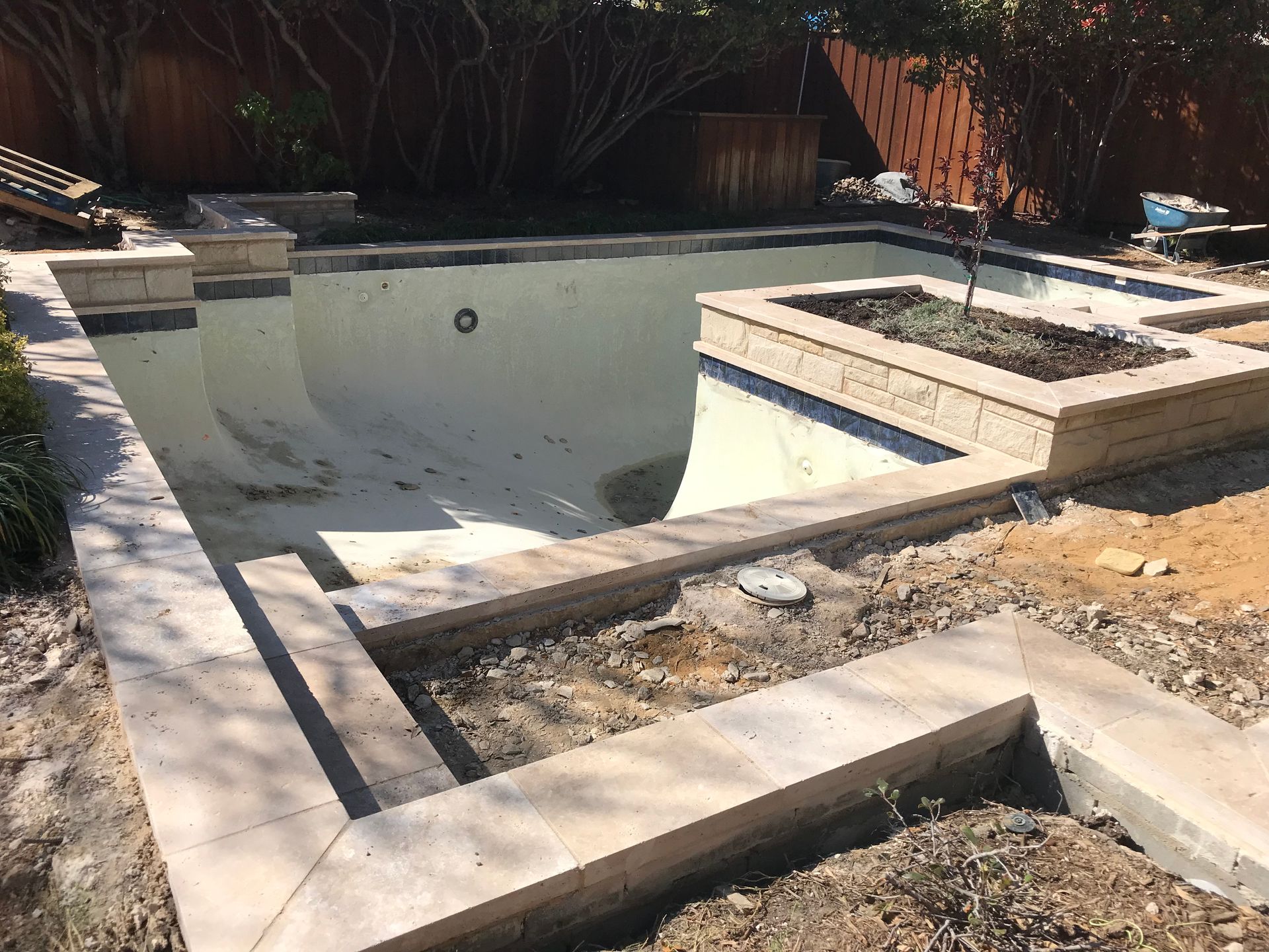 A large swimming pool is being built in a backyard.