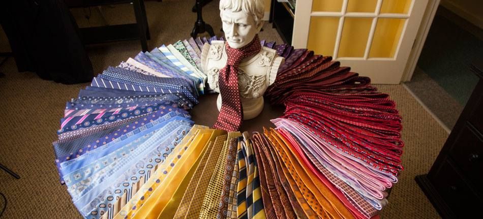 A statue of a man is surrounded by a circle of ties.