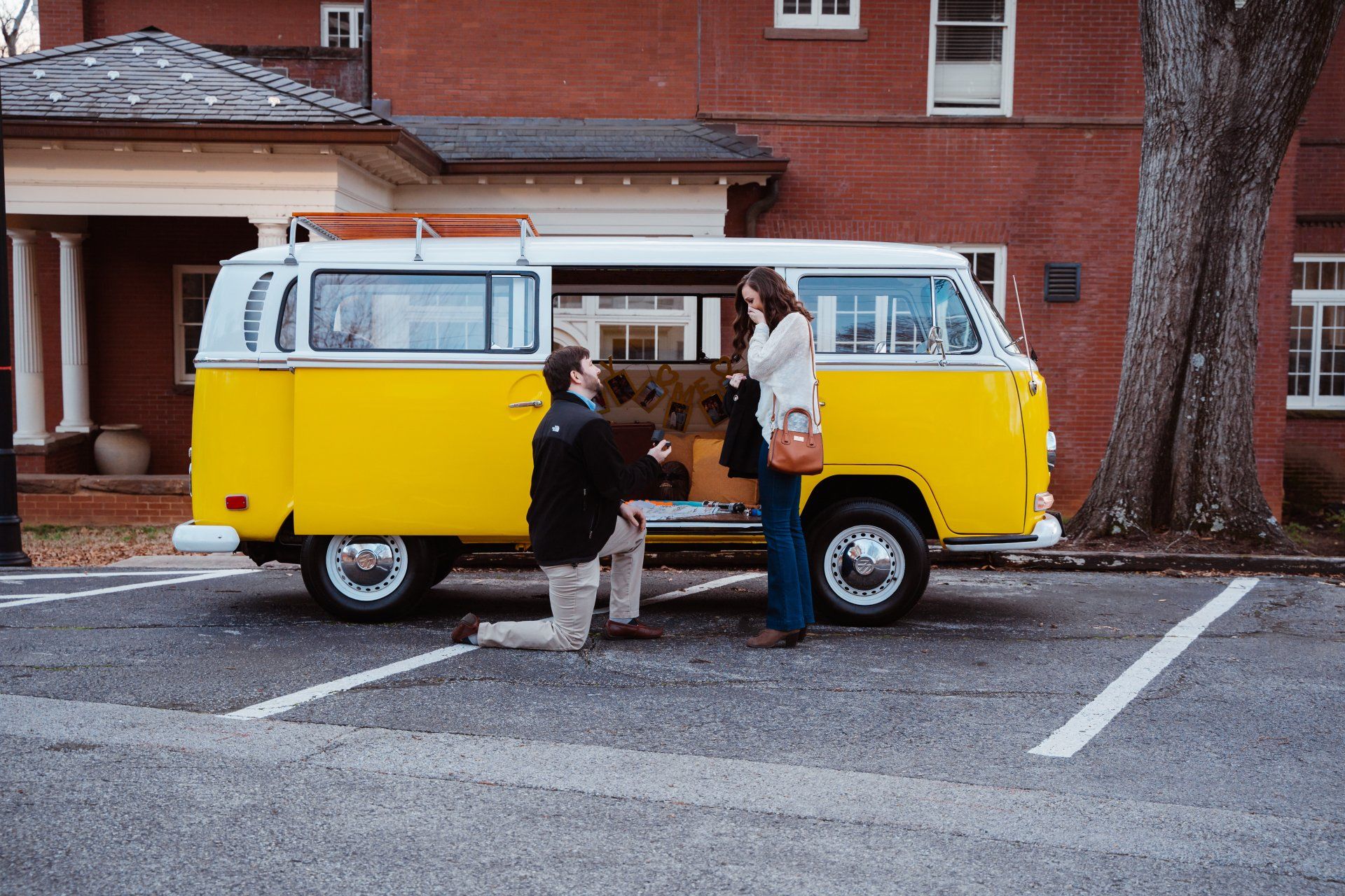 Young man proposes to girlfriend with a yellow vw bus