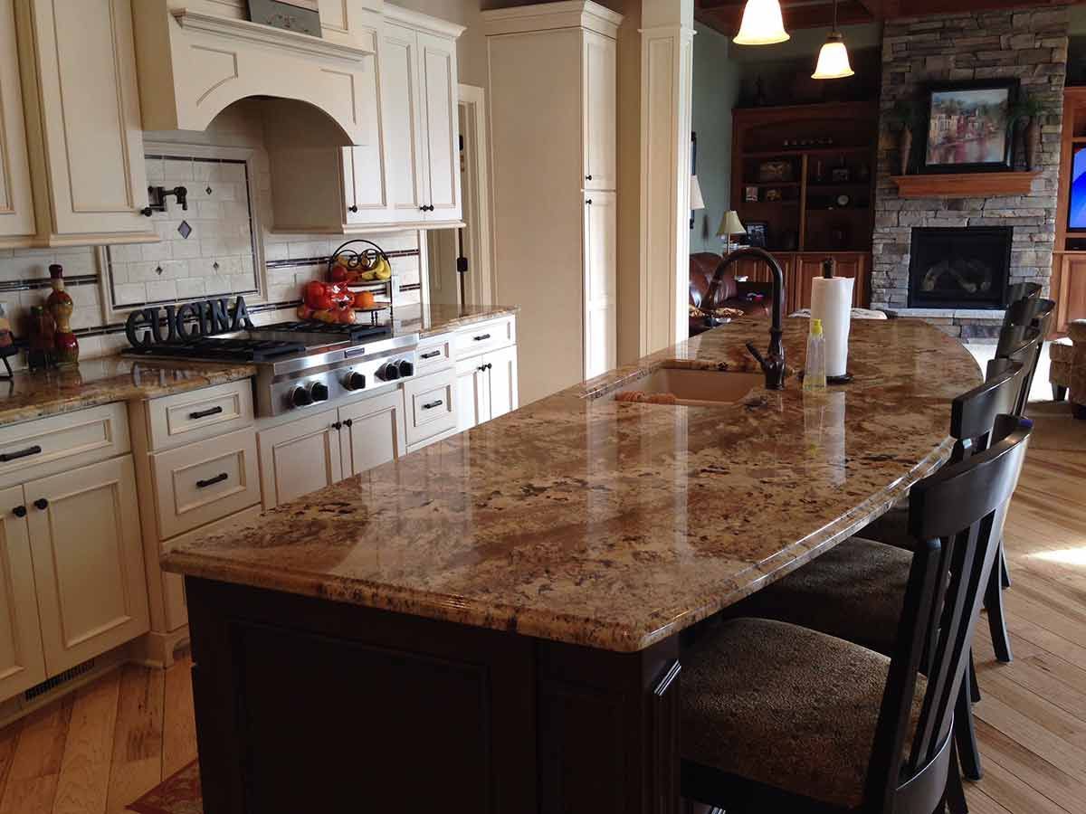 A kitchen with granite counter tops and white cabinets