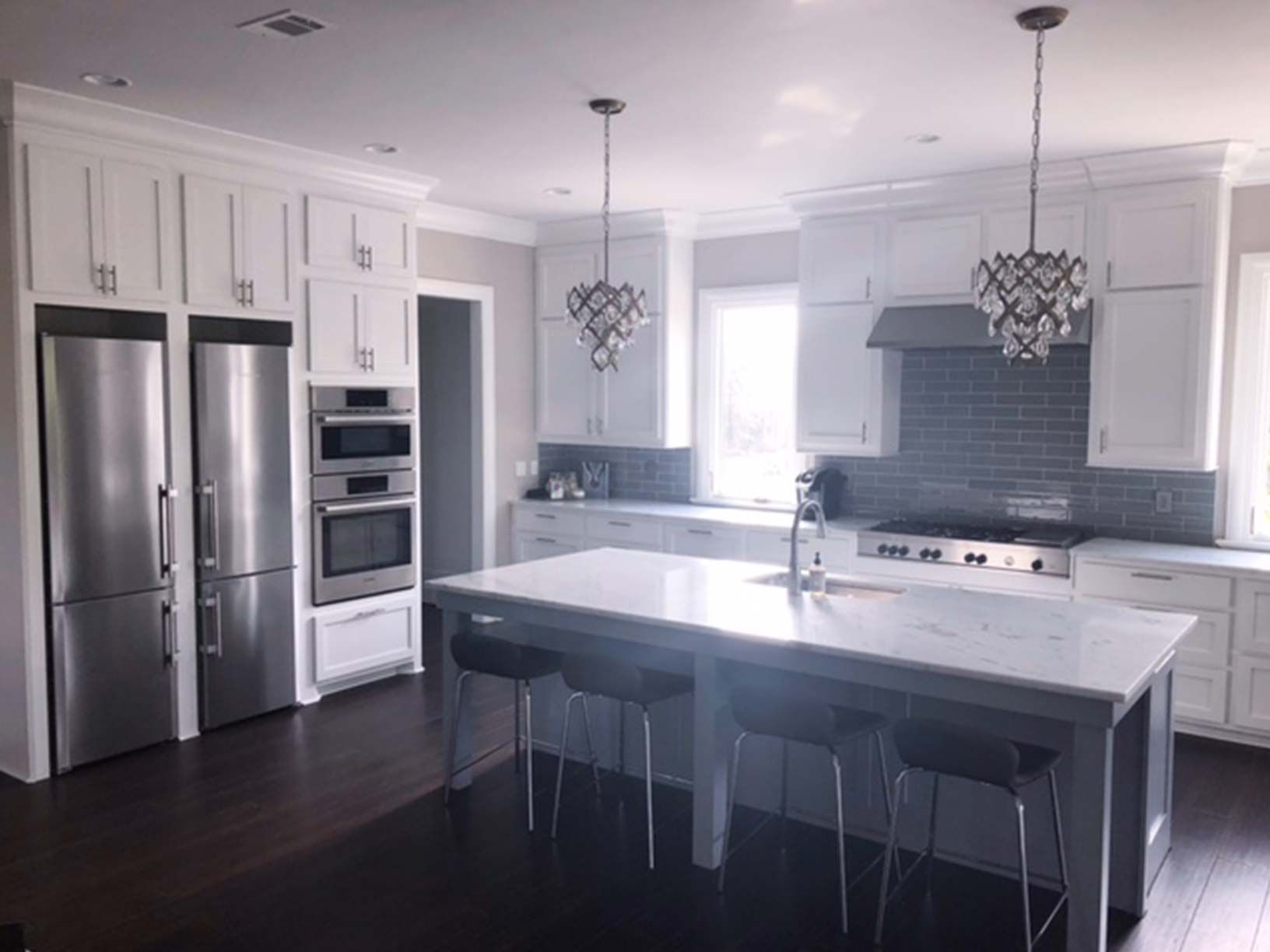 A kitchen with white cabinets and stainless steel appliances