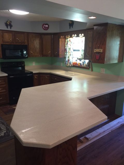 A kitchen with wooden cabinets and a white counter top
