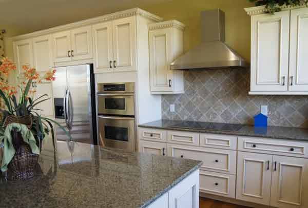 A kitchen with white cabinets and stainless steel appliances