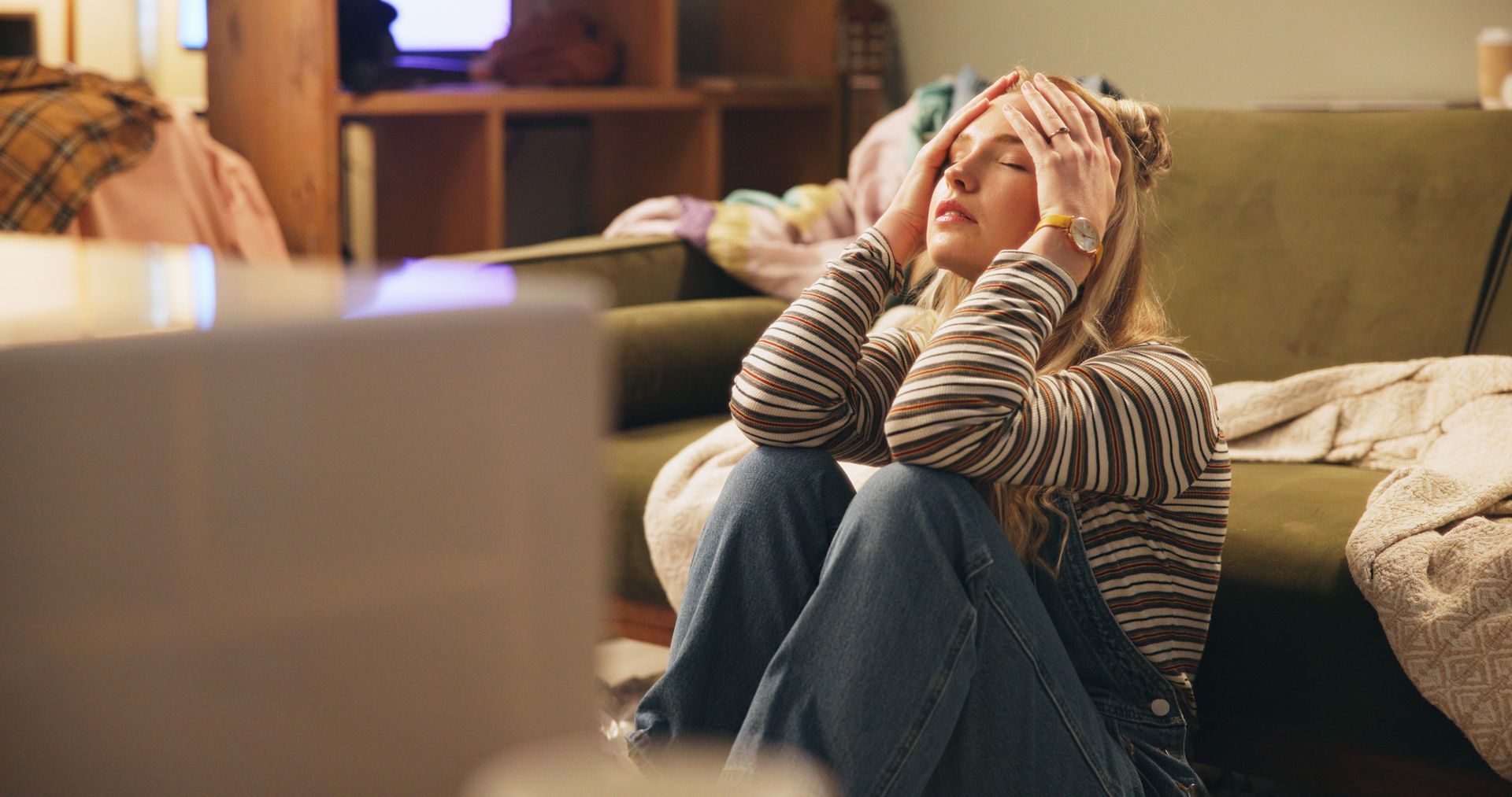 Woman sitting on the floor with hands on her head as she works through disappointment