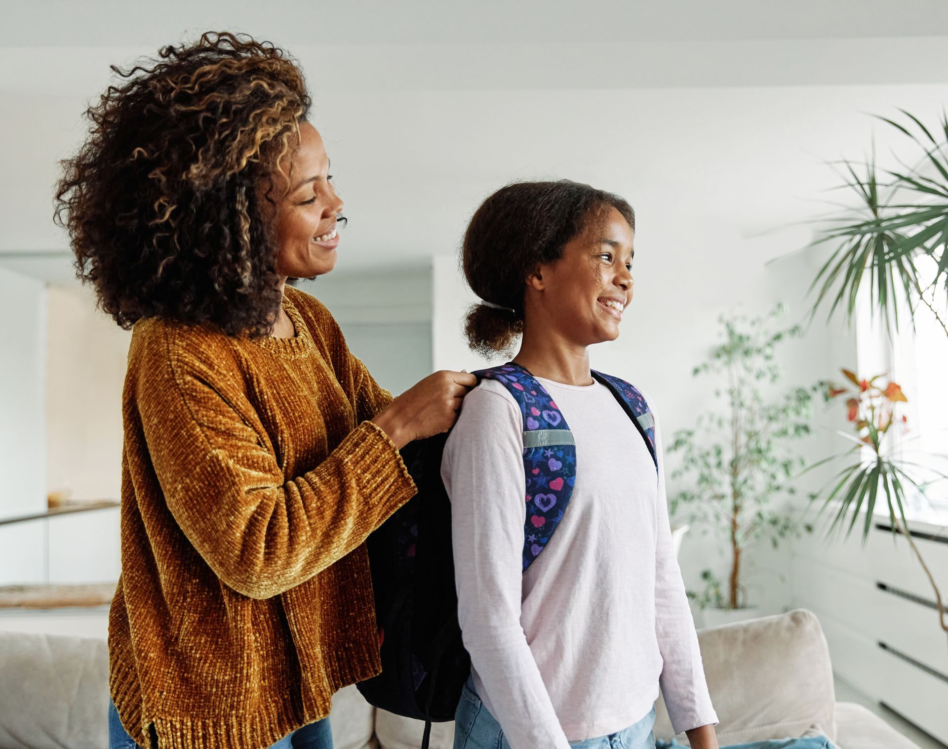 Woman helping a person with a backpack indoors.