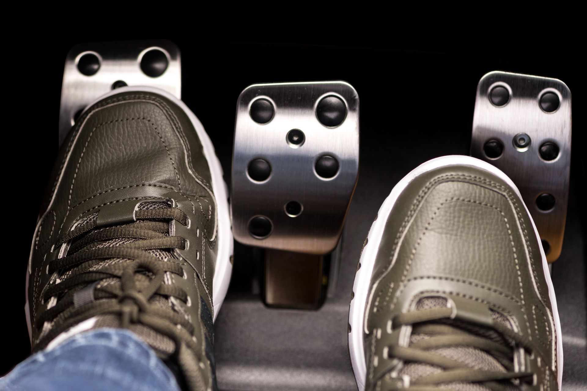 Foot on car pedals: clutch, brake, accelerator, in vehicle.