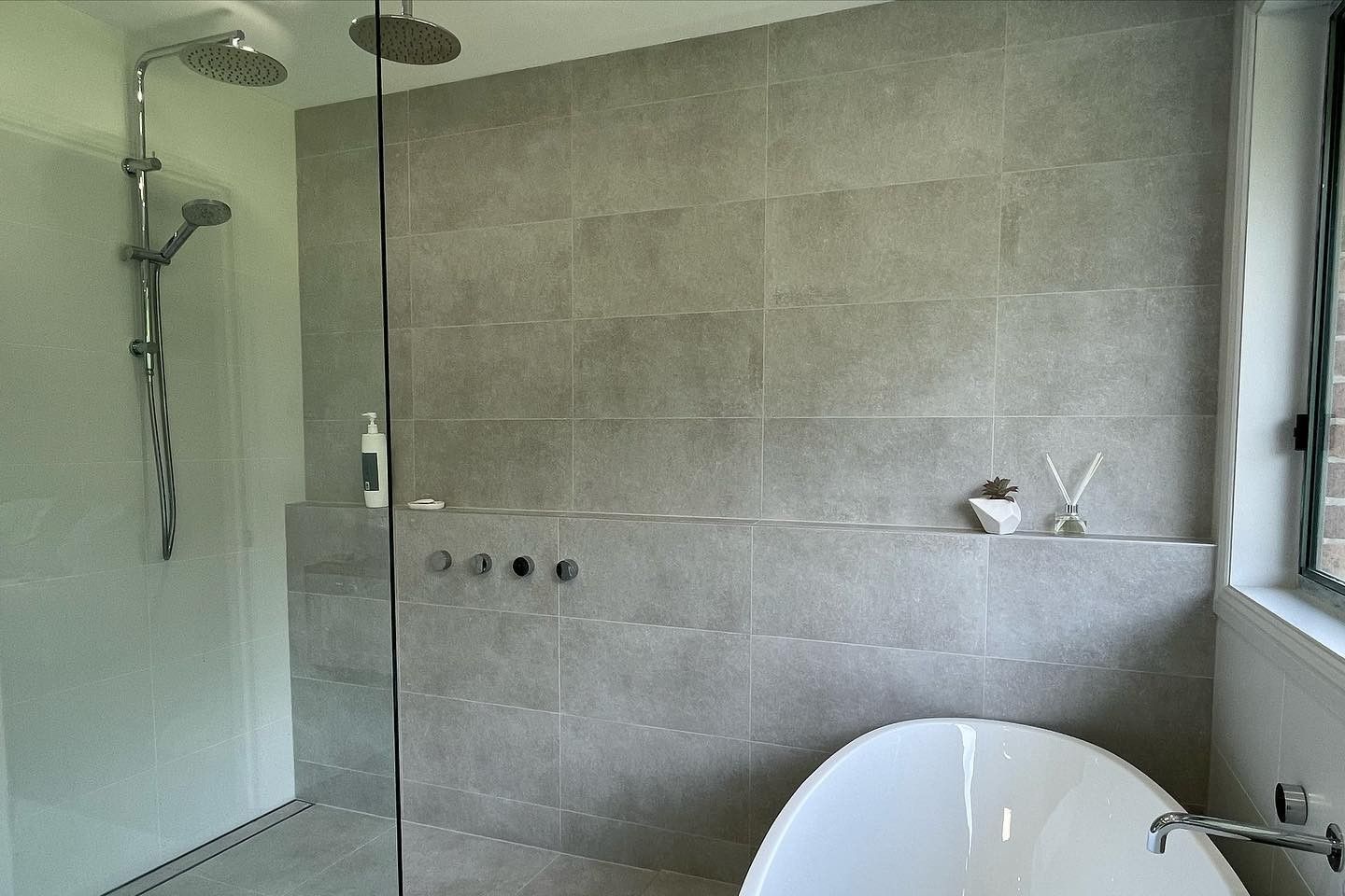 A Newly Renovated Bathroom With Grey Tiles