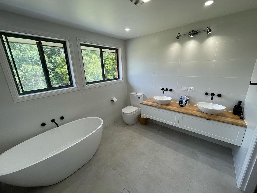 A Bathroom With Two Sinks, a Toilet, and a Bathtub — Firm Built Bathrooms in Wollongong, NSW
