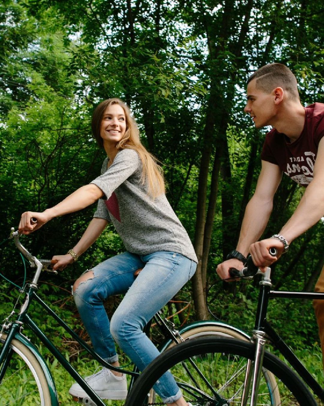 En ung kvinde og ung mand cykler og kigger på hinanden