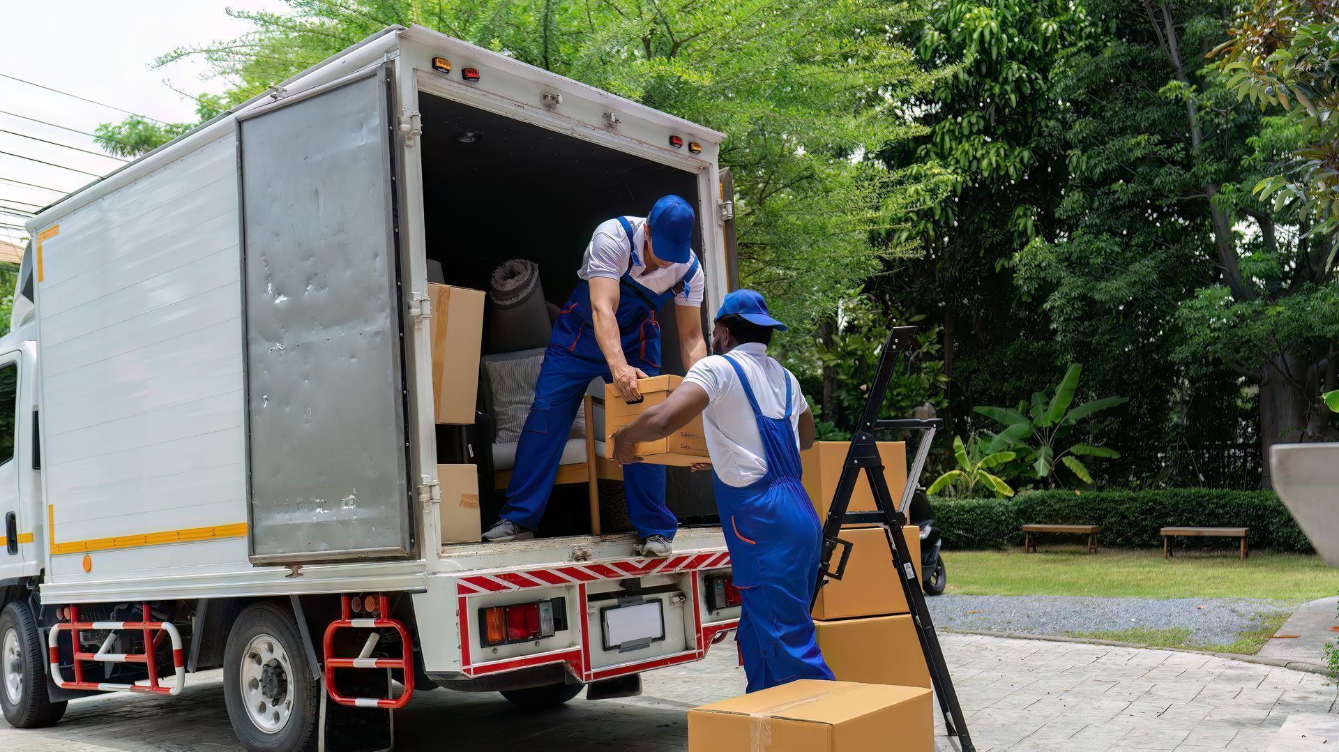 Two men are loading boxes into a moving truck.