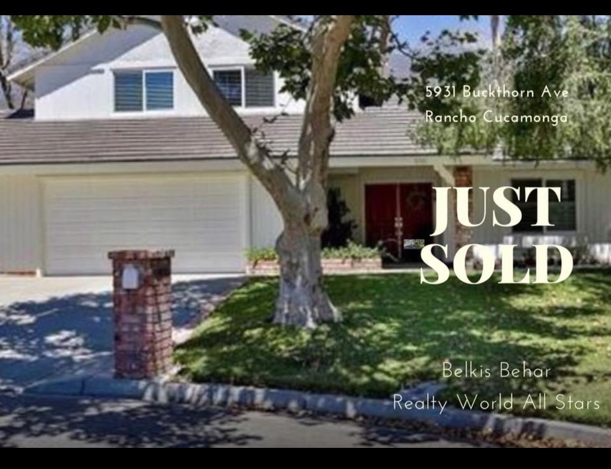 A dining room with a table and chairs and a wooden staircase.