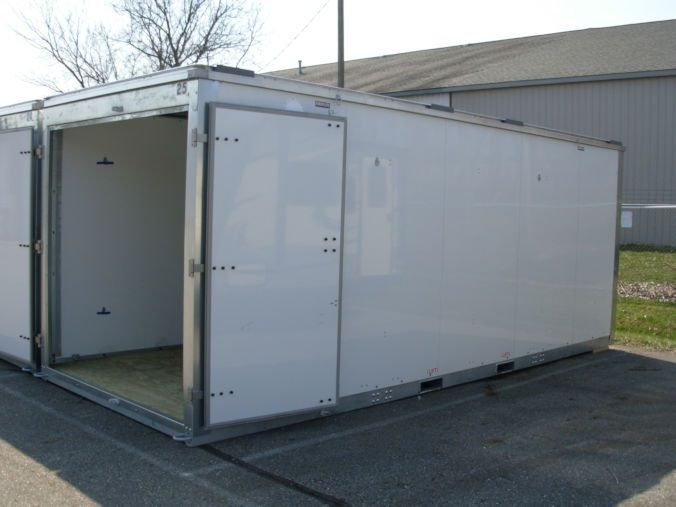 A white box with the door open is sitting in a parking lot