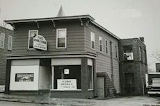 A black and white photo of a building in a small town.