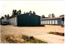 A large green building with a truck parked in front of it.