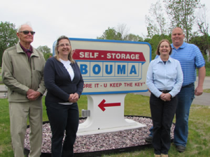 A group of people standing in front of a self storage sign