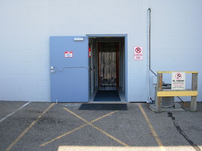A no parking sign is on the side of a building