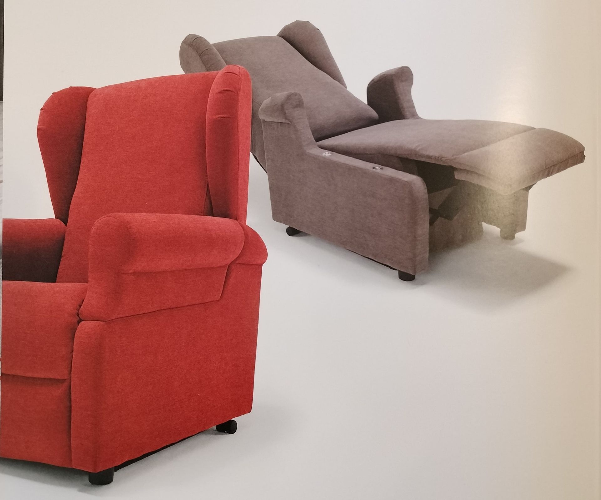 una sedia rossa è seduta accanto a una sedia grigia