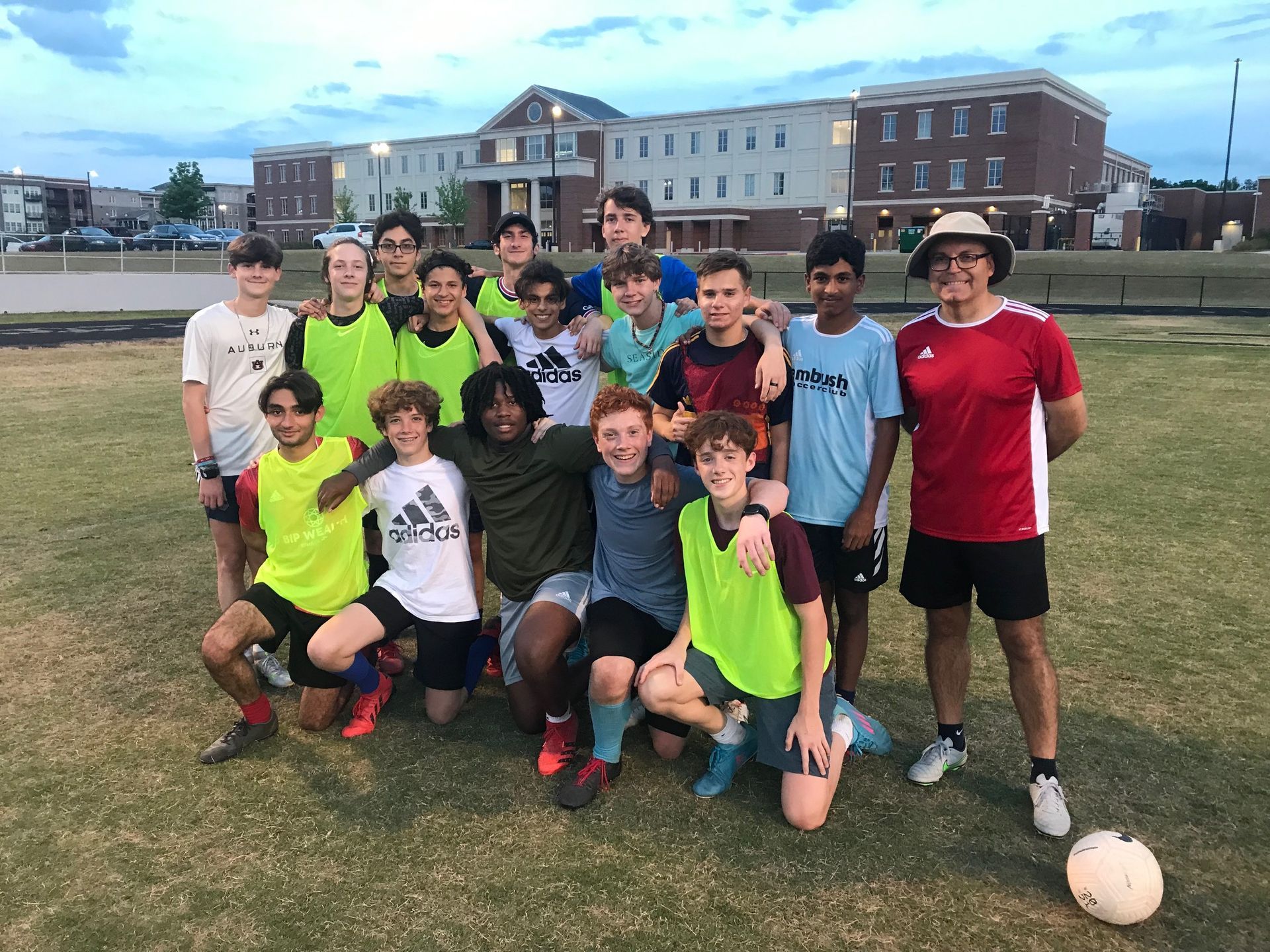 A group of Alpharetta Ambush Soccer Club syoung men are posing for a picture on a soccer field.