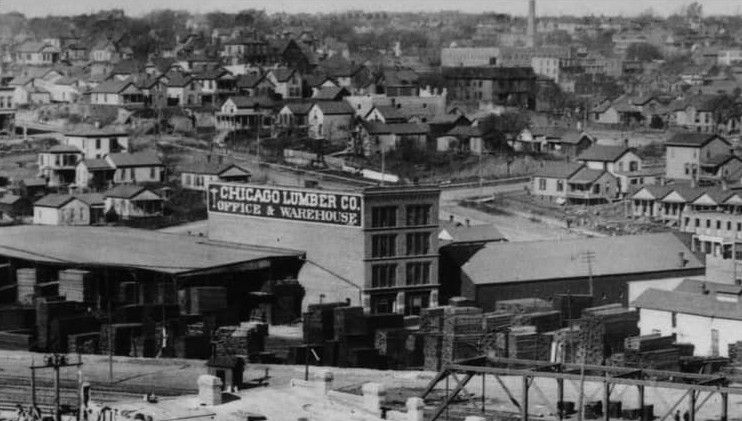 Black-and-white view of a dense hillside city with houses and buildings packed along the skyline.