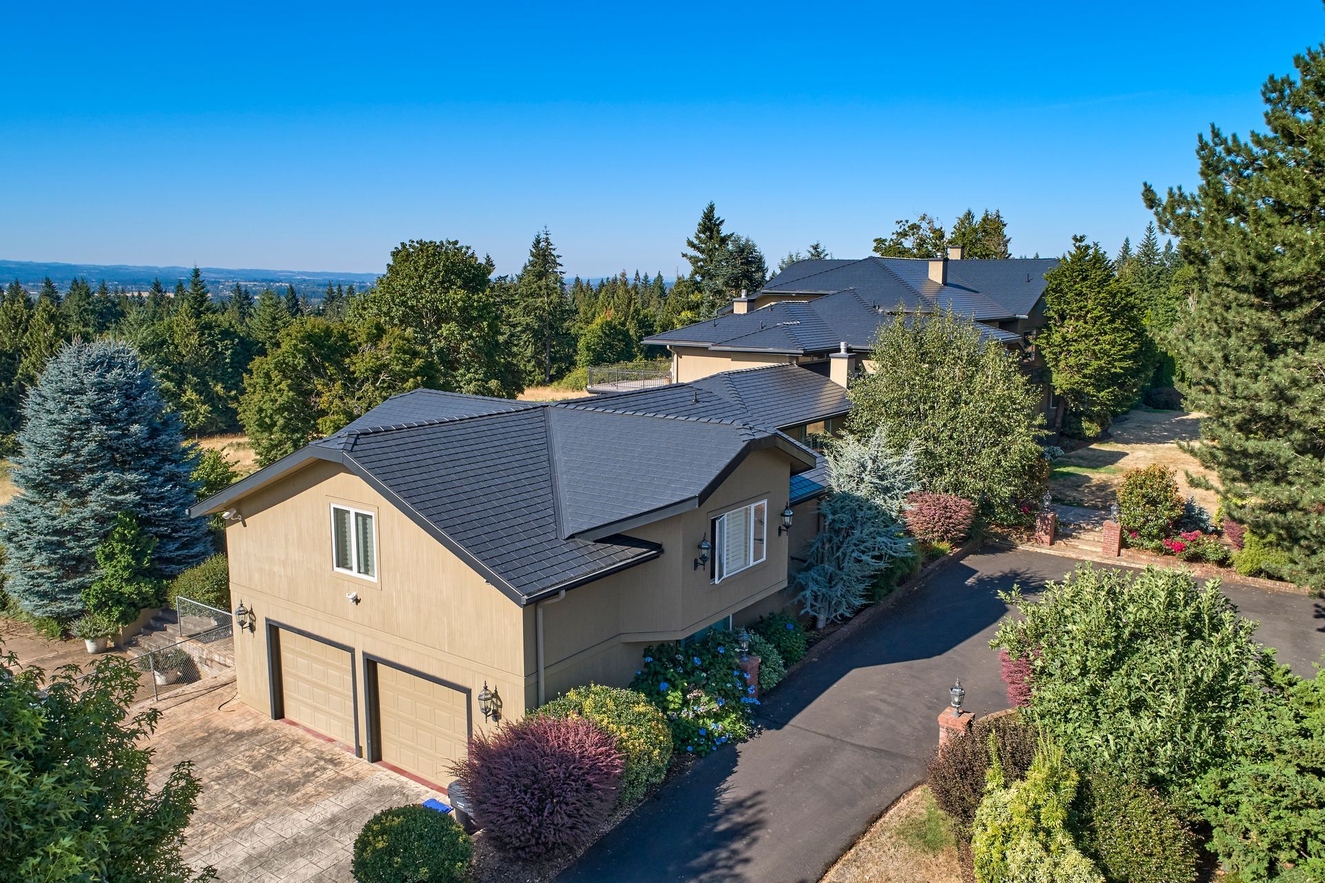 Wide-angle view of a black aluminum slate roof installed by Interlock Metal Roofing on a multi-structure estate in Mulino, Oregon. This lifetime metal roof system enhances curb appeal while offering fire-resistant and maintenance-free protection in Clackamas County.