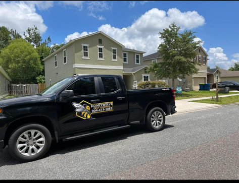 A man is spraying a window sill with a sprayer.