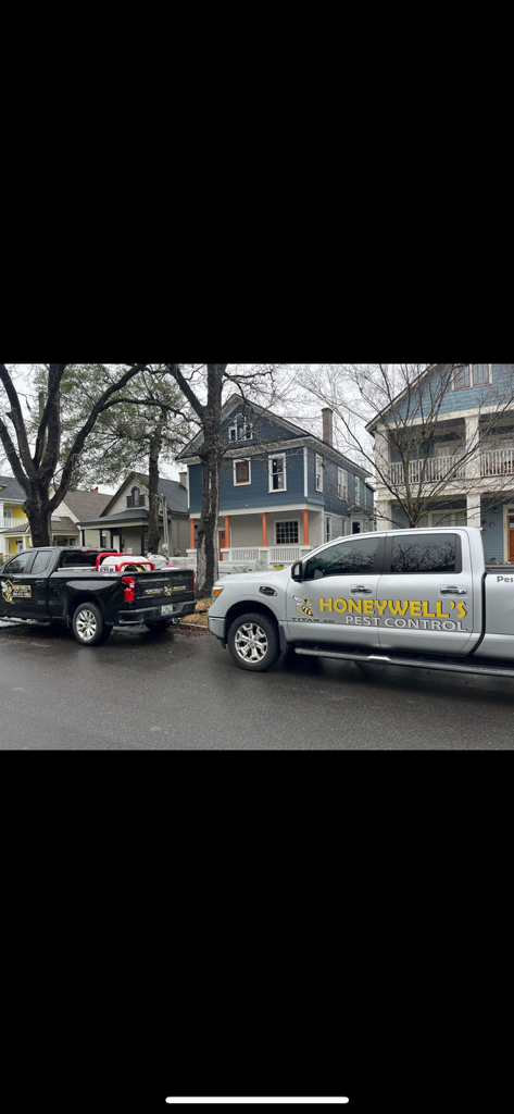A man in a protective suit is spraying a kitchen with a sprayer.