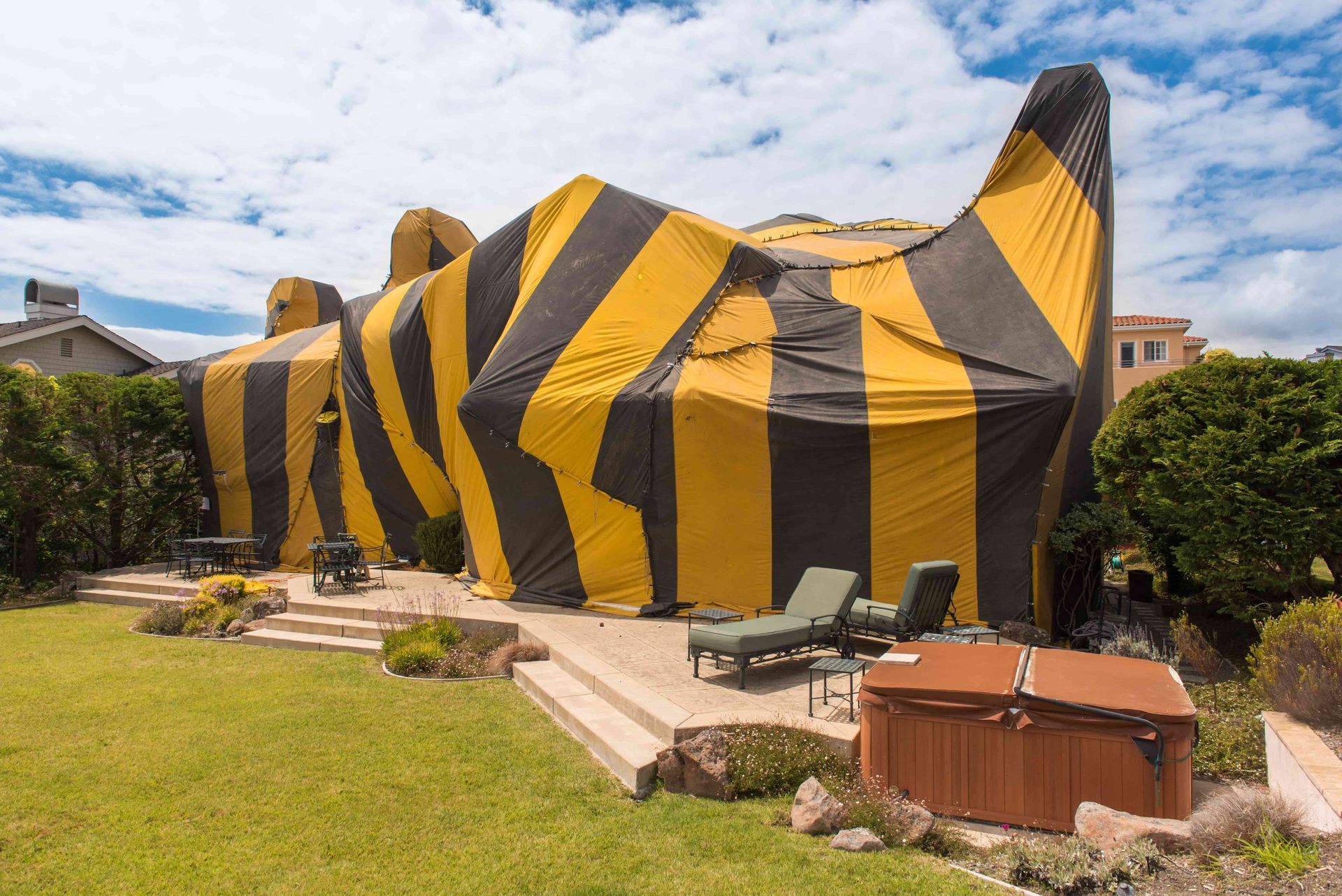 A house is covered in a yellow and black tarp.
