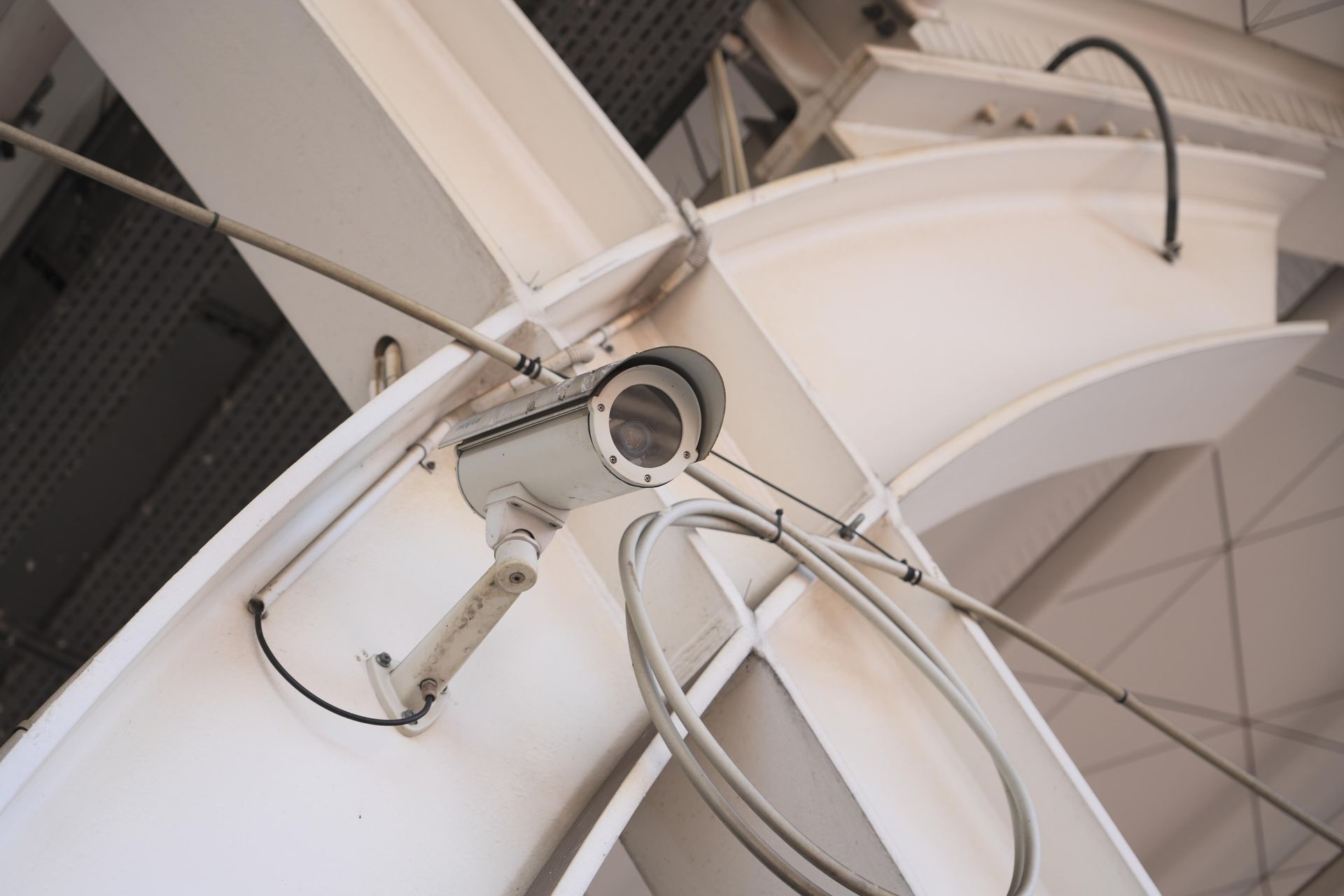 A security camera is mounted on a white wall.