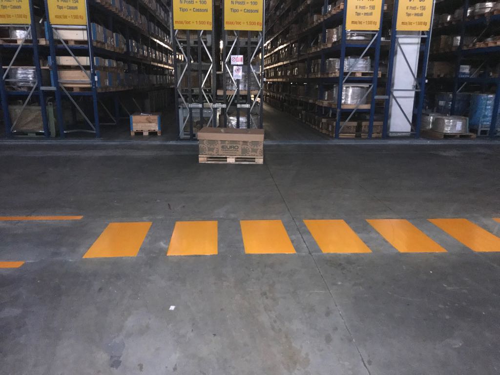 Segnaletica orizzontale in vernice gialla in un capannone