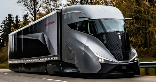 An electric transport truck with a full load traveling down the highway.
