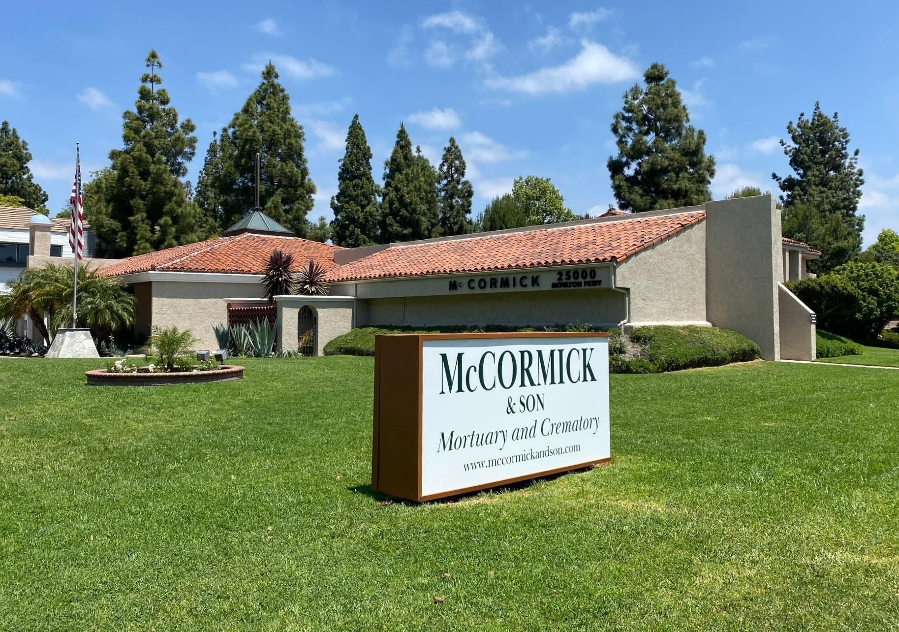 McCormick & Jones, Inc. building on a green lawn with a sign in front under a blue sky.
