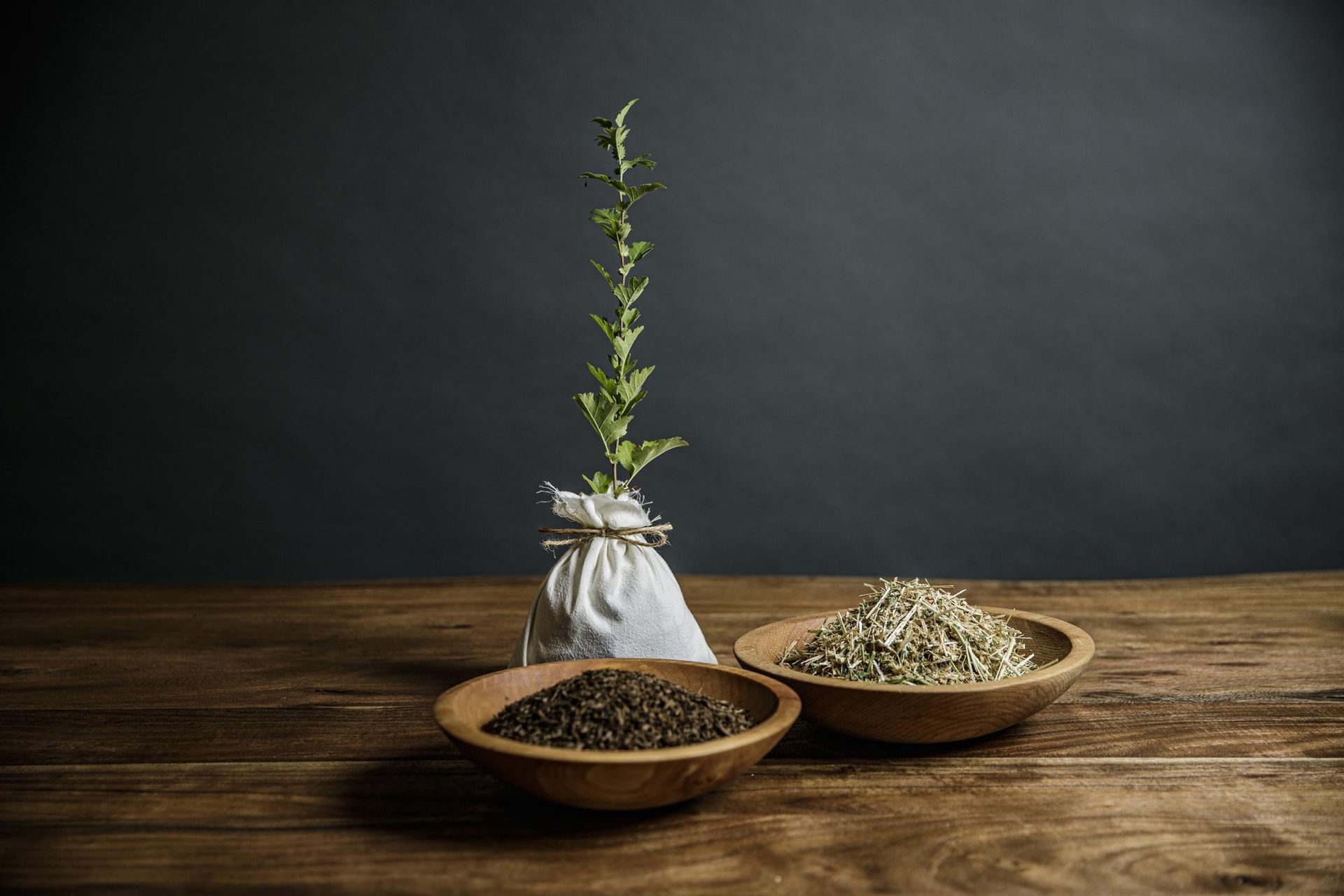 A black can is sitting on a table next to a vase of flowers.
