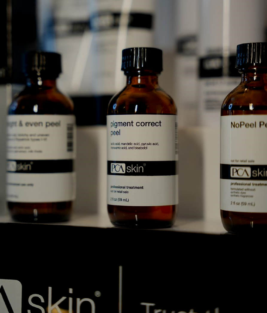 Three brown glass bottles of PCA skin products on a shelf.