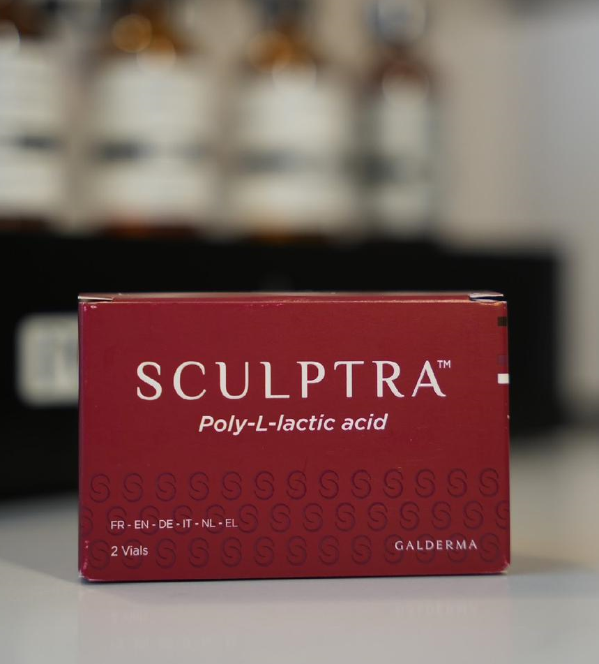 Box of Sculptra, a poly-L-lactic acid injectable, on a white surface, with brown vials in background.